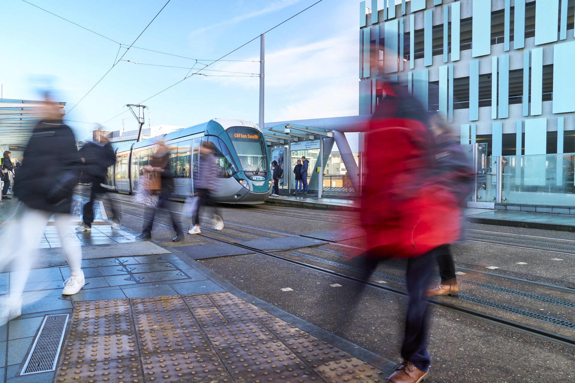 Transport Strategy: A tram on the tracks in Nottingham. Blurred images of people are in the foreground.