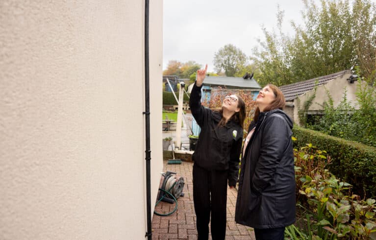 Mayor Claire and Celine Stretton look at the external wall insulation that has been installed to a home in Derbyshire as part of the domestic retrofit programme.