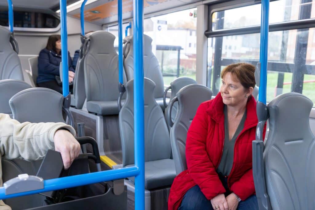 Mayor of the East Midlands, Claire Ward, chats with a fellow passenger on a bus.