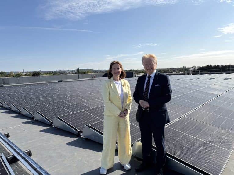 Mayor Claire Ward and Cllr Neil Clarke standing in front of the solar panels that have been installed on Rushcliffe Arena