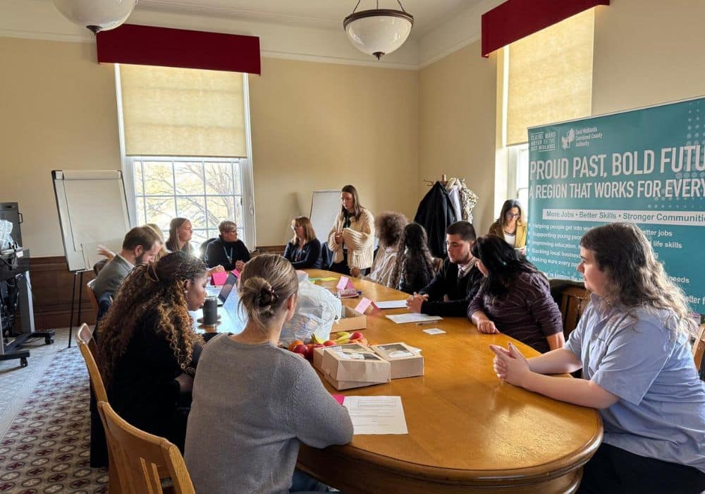 Youth committee members gather around a table during a meeting