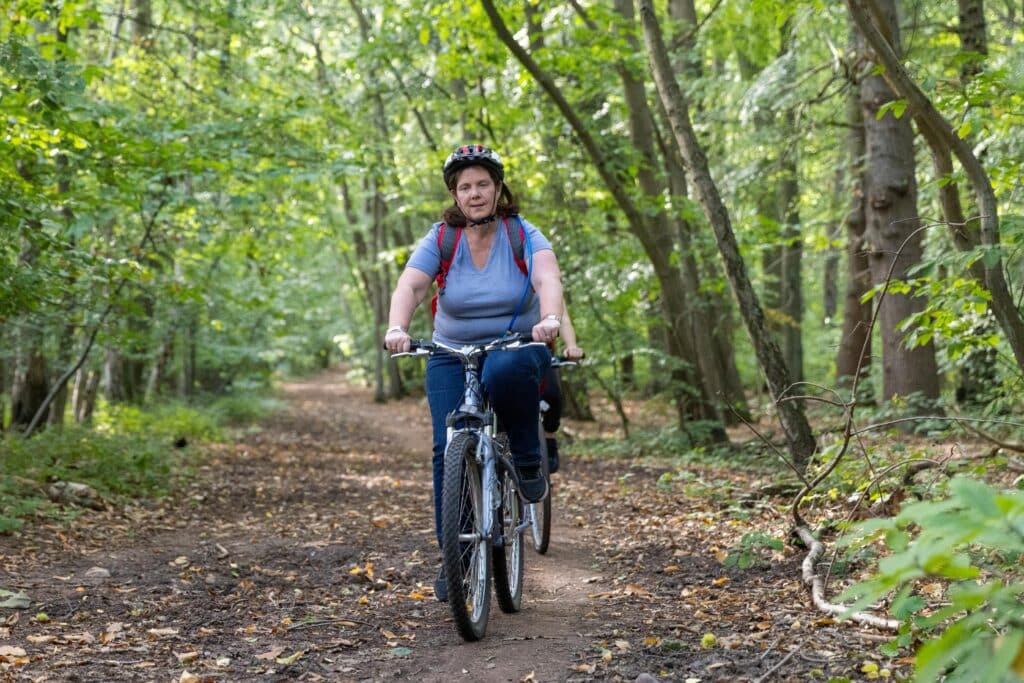 Mayor Claire riding through a forest path on a push bike.