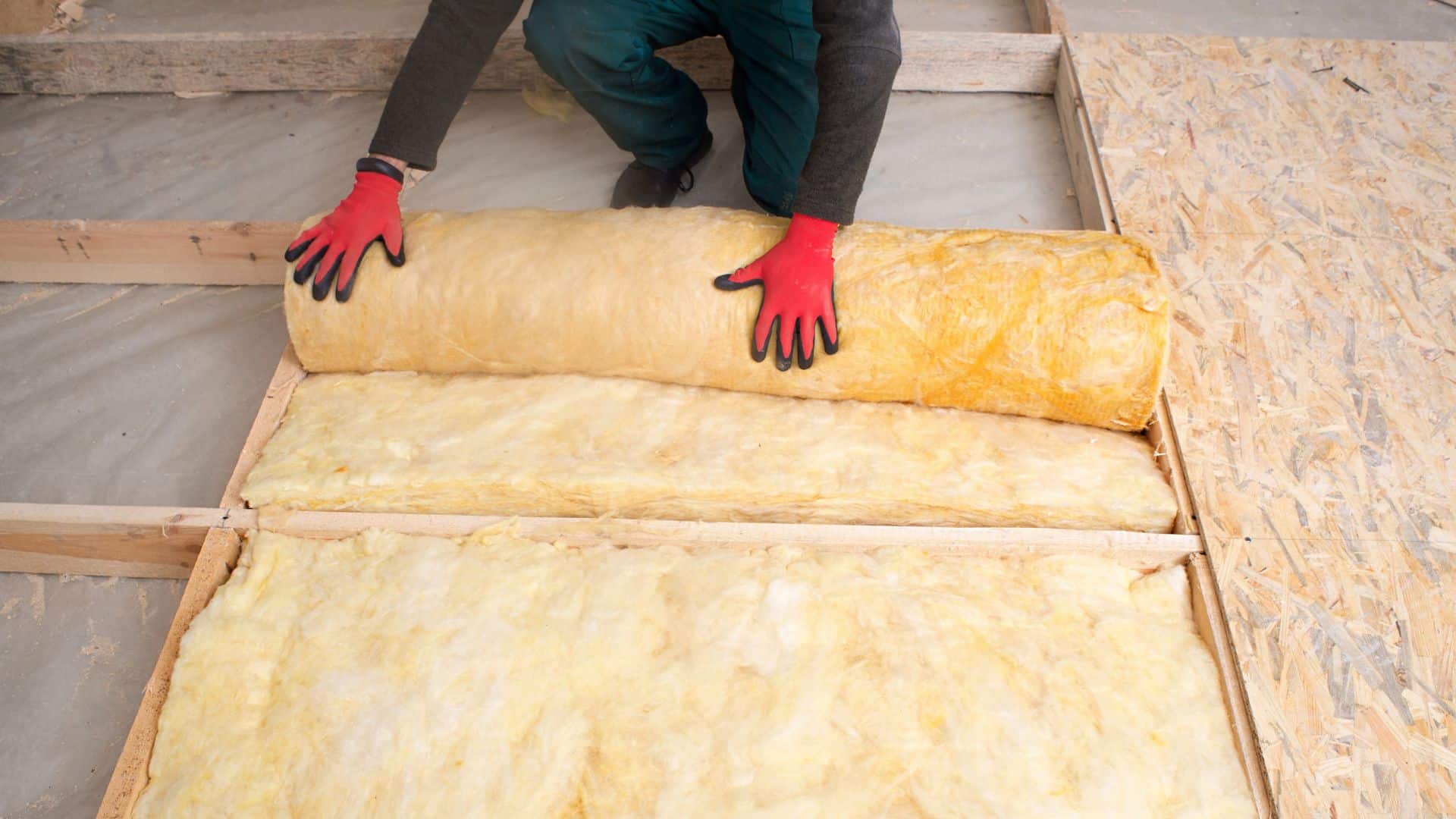 Person laying insulation in a loft. An example of retrofit options available.